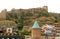 Narikala Ancient Fortress on the Hilltop with Beautiful Dome of Saint George`s Church in Foreground Seen from Old City of Tbilisi