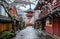 a narrow alley leading to a pagoda with white blossoms on either side