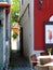 Narrow alley in old quaint town with white stucco walls and restaurant patio detail