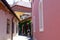 Narrow alley in old quaint town with white window trim and colorful stucco walls