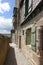 Narrow alleyway in the old town of Mont St Michel with a hanging sign for the Hermitage Hotel