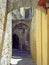 Narrow alleyway in rhodes old town with arches between old stone walls and an open doorway with stairs inside