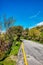 Narrow asphalt road and green meadow field