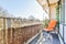 Narrow balcony with bright orange armchair