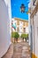 The narrow Calle Albucasis and trimmed trees in Juda Levi Square, Cordoba, Spain