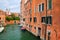 Narrow canal lined with houses in Venice, Italy