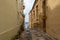 Narrow charming street in Senglea, Malta, with potted plants
