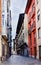 Narrow cobblestone street with facades of old houses with lots of color on the sides