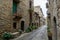 Narrow cobblestone street with massive brown stone houses