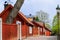 Narrow cobblestoned street on Asoberget with a typical wooden residential houses painted in falun red and with white shutters on