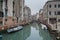 The narrow colorful street with a boat in Venice, Italy. Scenic beautiful view of Venice canal with reflection in the water