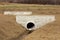 Narrow concrete bridge construction site built over large diameter plastic pipe and storm drain drainage outlet