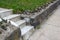 Narrow concrete steps between rock capped retaining walls, green grass
