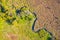 Narrow creek meanders in autumnal landscape from above