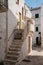 Narrow deserted street, stairs and white houses