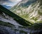 Narrow and difficult rocky trekking trail across mountain to a lake mountains in background at Tirol region, Austria