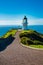 Narrow footpath leading to Cape Reinga Lighthouse. Bright summer day at the northernmost point of North Island, New