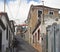 Narrow hillside street in funchal madeira with old Portuguese houses with shutters with a blue sunlit sky