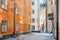 Narrow historical houses in Gamla Stan, Old Town, and senior sitting and cilling outside