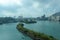 Narrow island with green grass in the sea. Bay with the gulf and the ships. Long Bay Bridge in Hong Kong. T