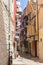 Narrow italian street with balconies, drying clothes and bike. Traditional mediterranean architecture. Italian town landmark.