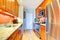 Narrow kitchen interior with orange back splash and granite tops