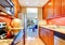 Narrow kitchen interior with orange back splash and granite tops