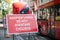 Narrow lanes road traffic sign protecting cyclists, with red London Double Decker Buses passing in the background