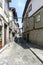 Narrow lonely alley with uneven cobblestone floor and Gothic style houses with stone facades in a village in Portugal called Guima