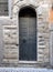 narrow medieval black wooden door in Bergamo