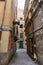 Narrow medieval street of stari grad, the old town of Rijeka, with medieval buildings about to collapse, decaying, in a dark spot