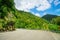 Narrow monutain road winding through green ranges of Waioeka Gorge. North Island, New Zealand