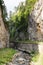 Narrow motor road along a mountain river in the gorge of the Rhodope Mountains, abundantly overgrown with deciduous and evergreen