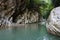 Narrow mountain blue river canyon in greenforest in caucasus mountains