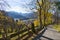 Narrow mountain road with a beautiful view of a lake as a background during Autumn