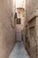 Narrow old abandoned street with Brock walls and plain wall in Medina district in Marrakesh