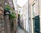 Narrow old alley with houses and decorative flowers.