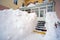 Narrow passage covered with snow in the porch of building.