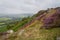 Narrow path between rocks and heather to the top of Curbar Edge on a grey summer morning