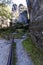 Narrow path seen going in between tall rock formations and a fence