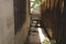 Narrow Pathway Between House and Wooden Fence