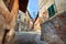 Narrow paved street among houses in Saluzzo.
