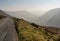 Narrow road besides misty valley in North Wales