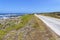 A narrow road runs parallel to the rocky shore of Robben Island