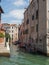 Narrow, romantic street and canal on a sunny day in Venice