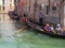 Narrow, romantic street and canal on a sunny day in Venice with gondola