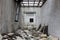 Narrow room at destroyed abandoned industrial complex filled with piles of rubble and construction material