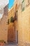 Narrow silent street with lantern and balcony in Mdina