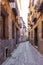 Narrow Spanish medieval cobbled street with old residential houses, Toledo, Spain.