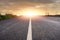 Narrow straight asphalt road with white markings at sunset. Dramatic sky. Nobody. Low angle of view. Travel concept. Motion blur